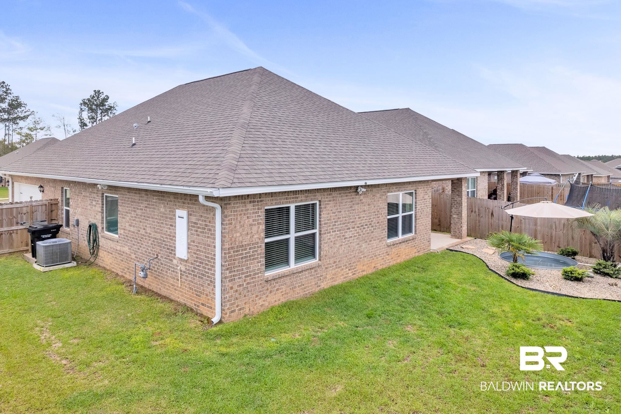 31650 Memphis Loop Daphne, AL 36527 - Photo 48 of 68 Rear view of house with a fenced backyard, a shingled roof, brick siding, and a patio area