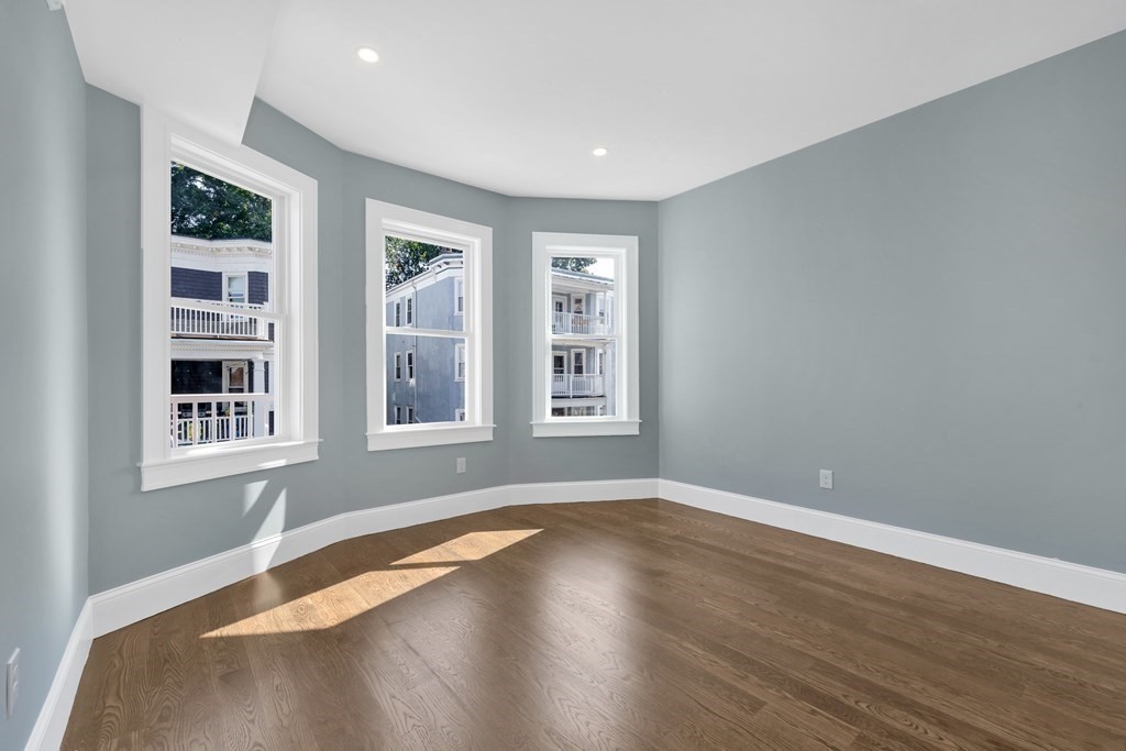 91 Parkton Road, Unit 1 Boston, MA 02130 - Photo 23 of 35 a view of an empty room with a window and wooden floor