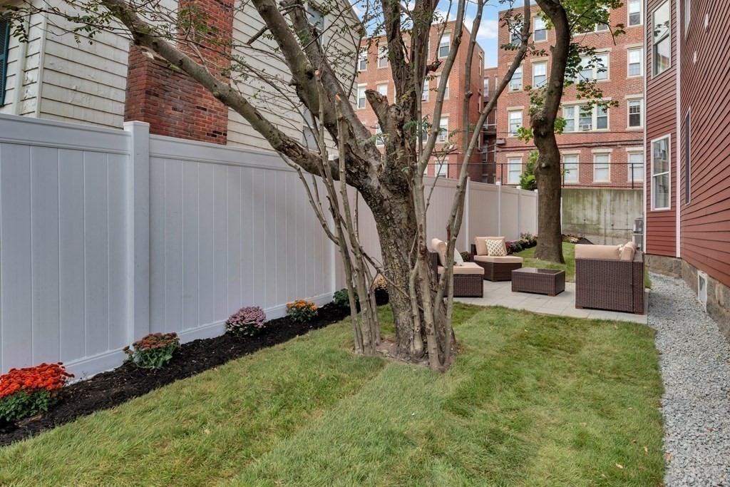 91 Parkton Road, Unit 1 Boston, MA 02130 - Photo 30 of 35 a backyard of a house with table and chairs