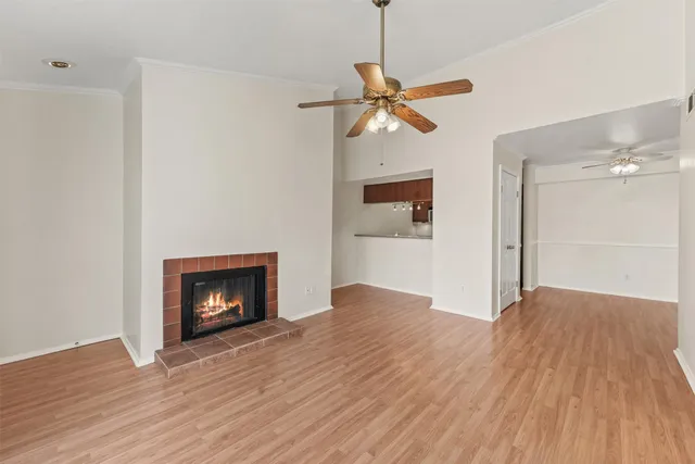 a view of empty room with wooden floor fireplace and a window