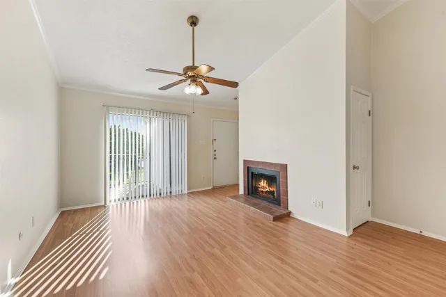 a view of a livingroom with wooden floor and a ceiling fan