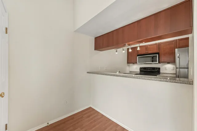 a view of kitchen with stainless steel appliances wooden floor