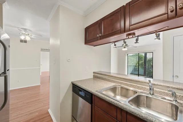 a kitchen with a sink cabinets and wooden floor