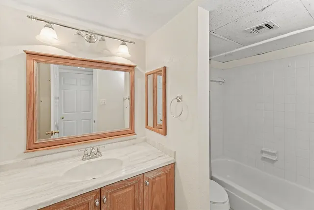 a bathroom with a granite countertop sink toilet and shower