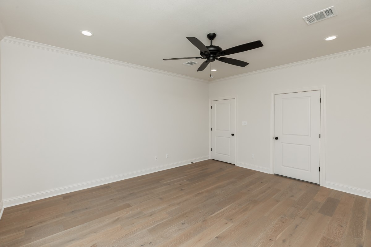 6560 Brayfield Lane Beaumont, TX 77706 - Photo 20 of 38 a view of a big room with wooden floor closet ceiling fan and windows