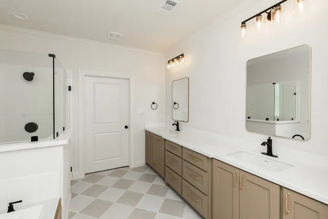 a bathroom with a double vanity sink mirror and shower
