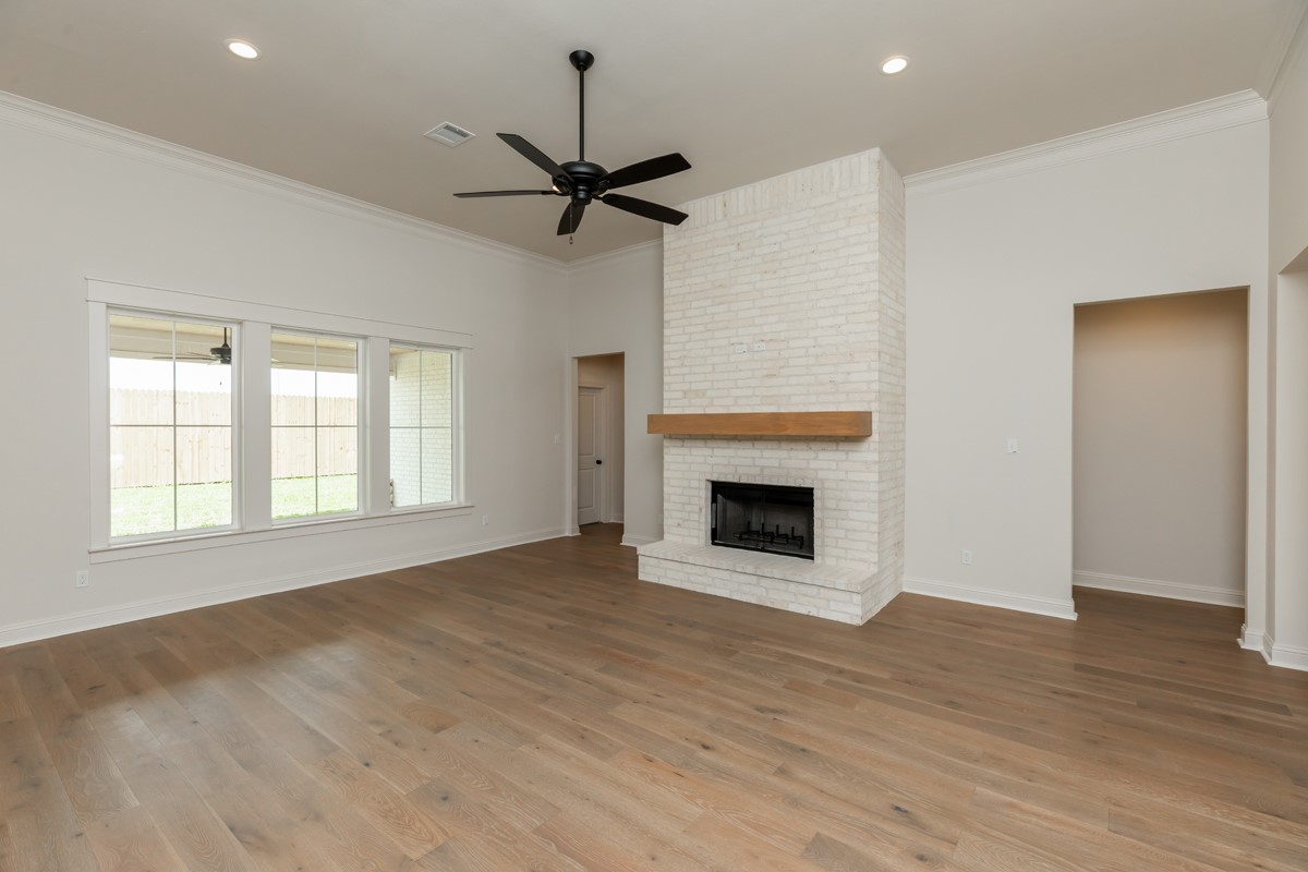 6560 Brayfield Lane Beaumont, TX 77706 - Photo 6 of 38 an empty room with windows fireplace and wooden floor