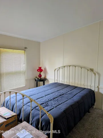 a bed sitting in a bedroom next to a window