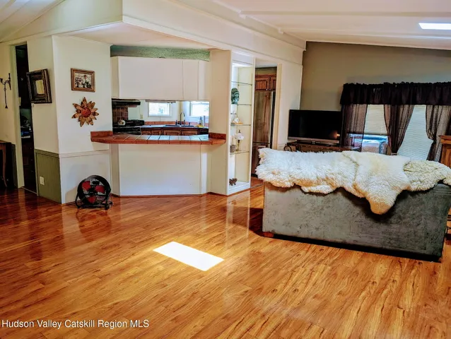 a living room with hard wood floors and a flat screen tv