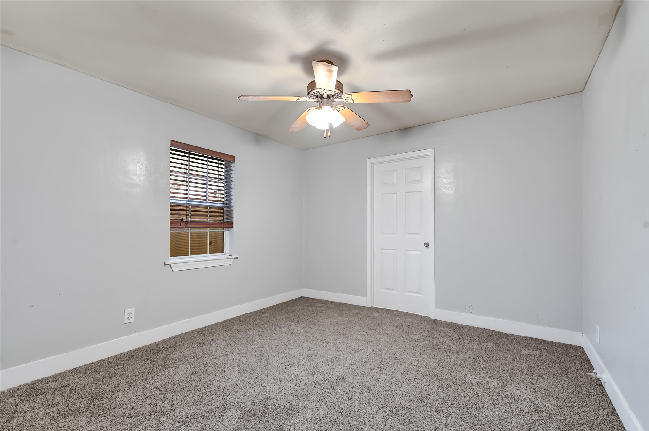 6825 Appleton Street Houston, TX 77022 - Photo 11 of 25 an empty room with windows and fan