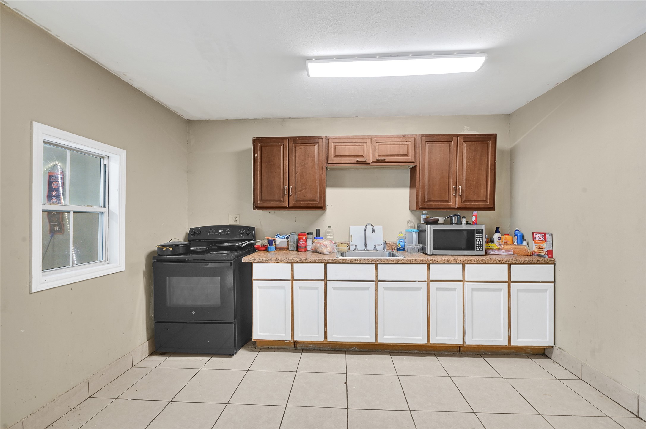6825 Appleton Street Houston, TX 77022 - Photo 20 of 25 a kitchen with granite countertop a stove top oven and cabinets