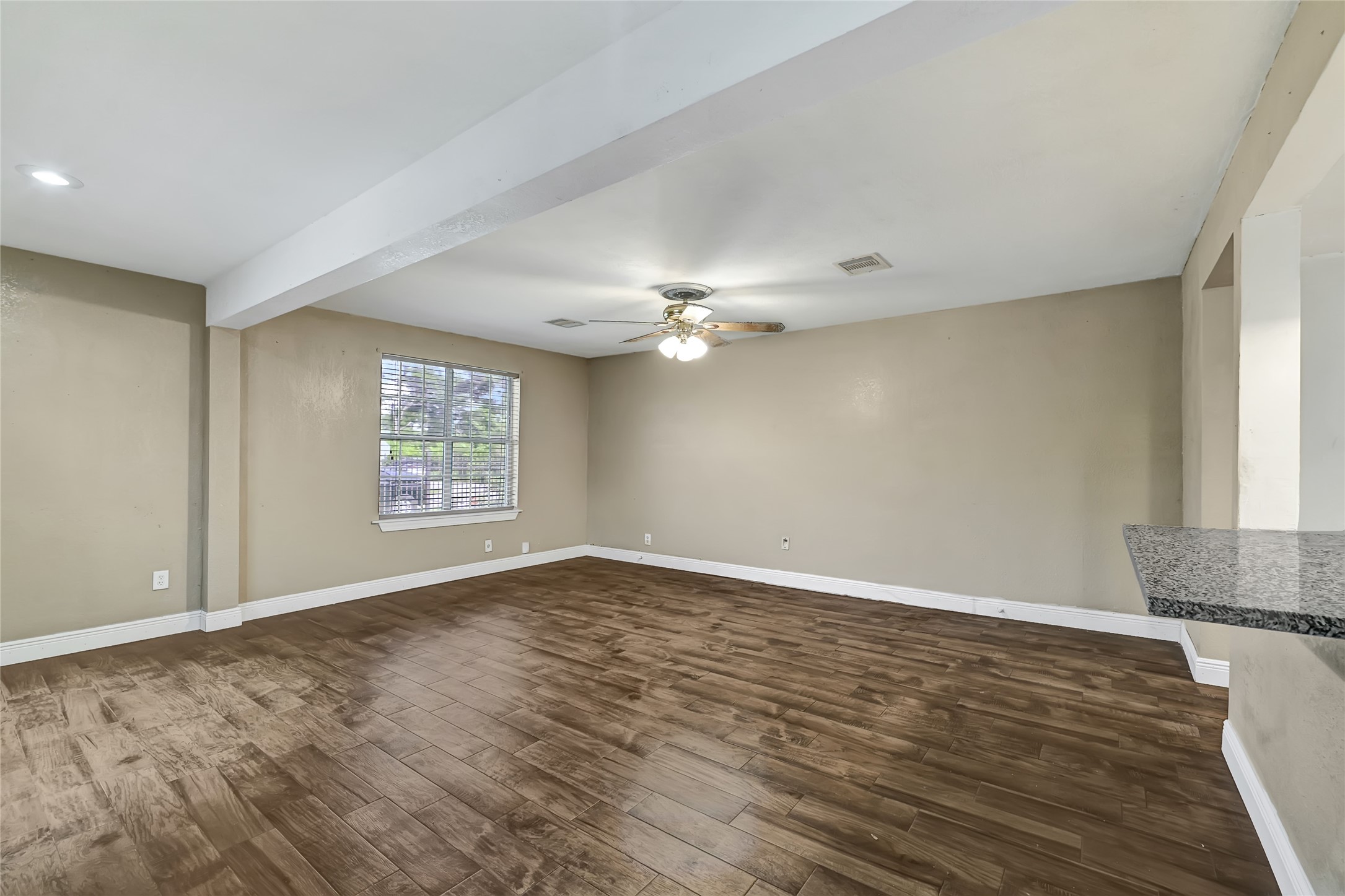 6825 Appleton Street Houston, TX 77022 - Photo 4 of 25 a view of an empty room with a window and wooden floor