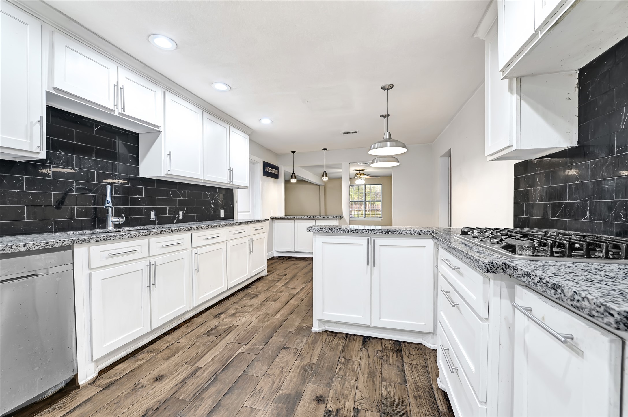 6825 Appleton Street Houston, TX 77022 - Photo 9 of 25 a large kitchen with stainless steel appliances granite countertop a stove a sink dishwasher and a microwave oven with white cabinets