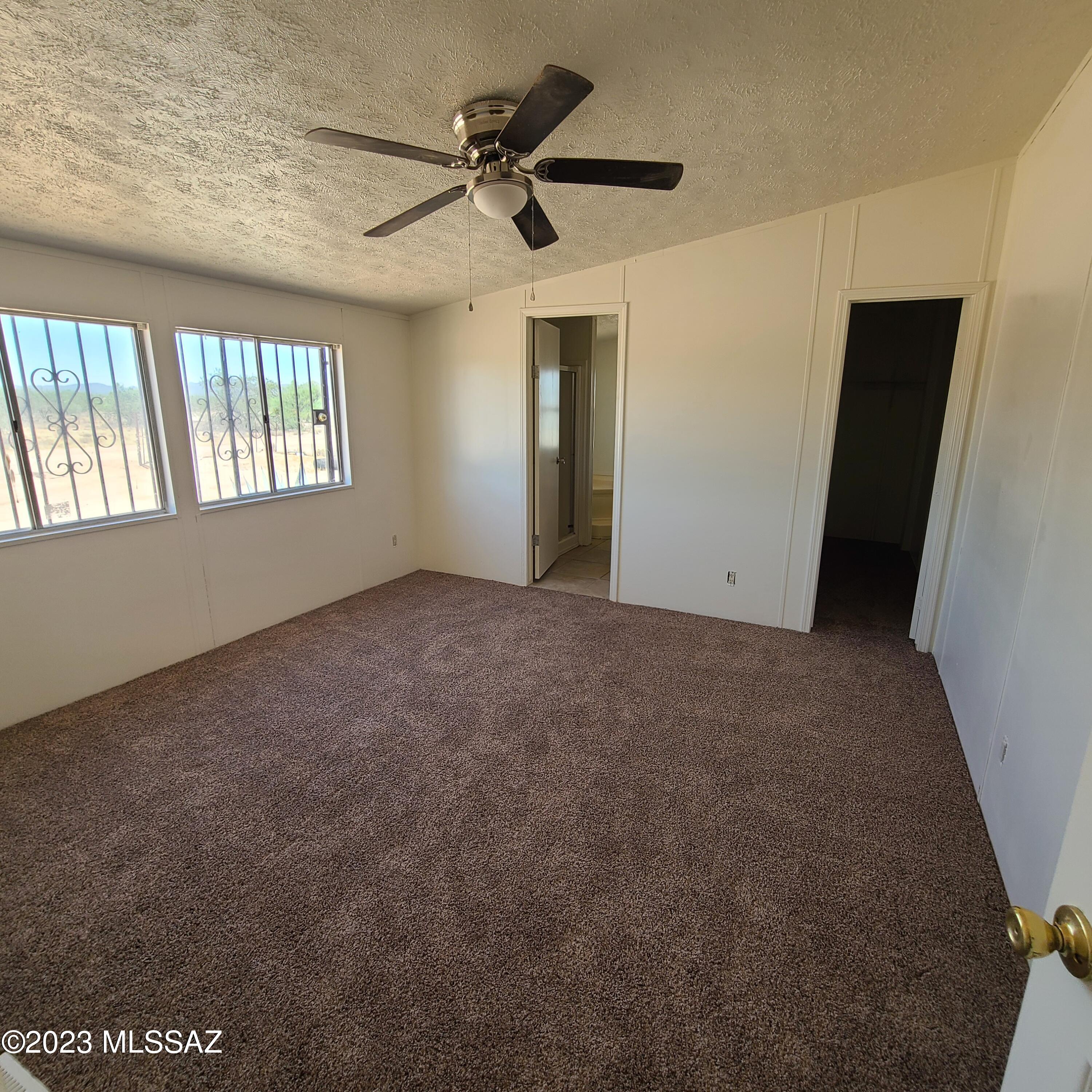 8896 South Marstellar Road Tucson, AZ 85736 - Photo 22 of 39 en empty room with windows and fan