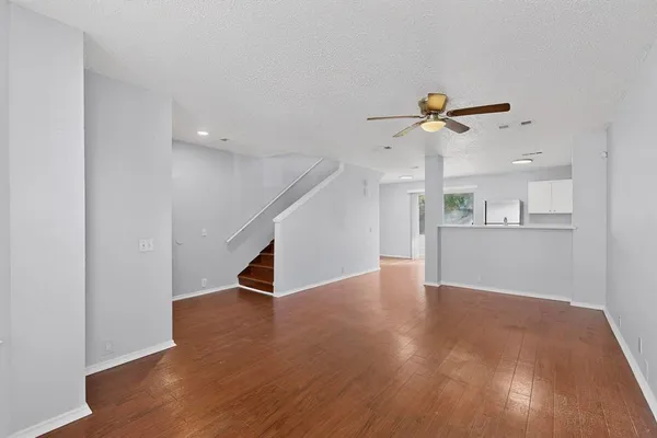 a view of an empty room with a window and wooden floor
