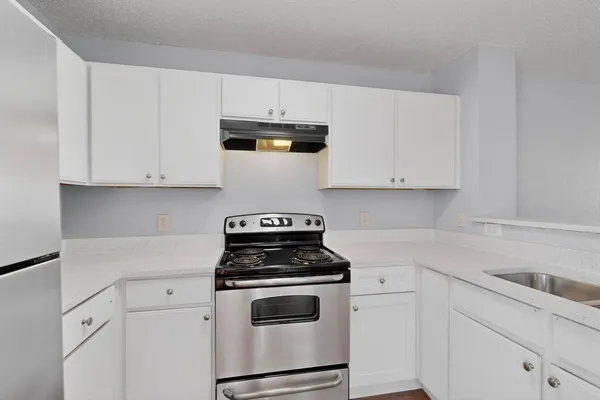 a kitchen with white cabinets and white appliances