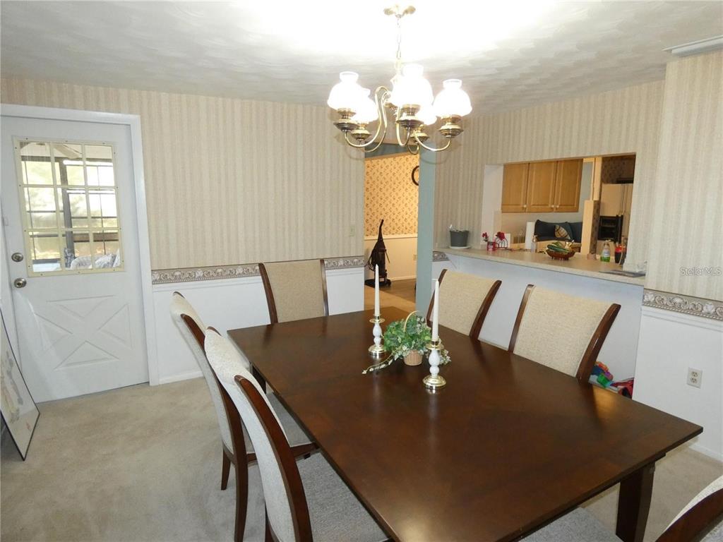 4392 Craftsbury Drive New Port Richey, FL 34652 - Photo 14 of 41 a view of a dining room with furniture and chandelier