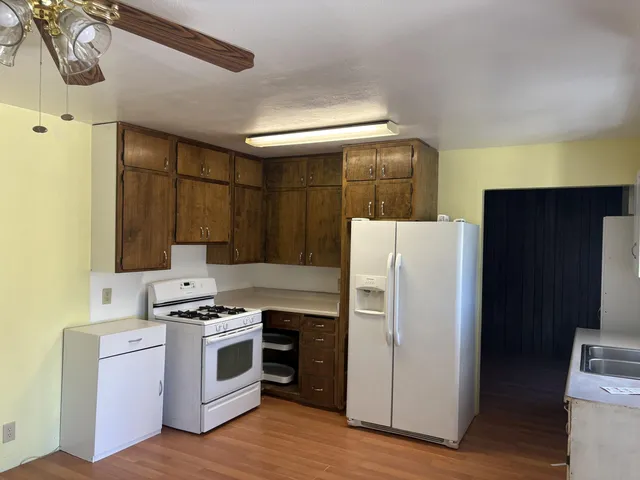 a kitchen with a stove a refrigerator and a sink