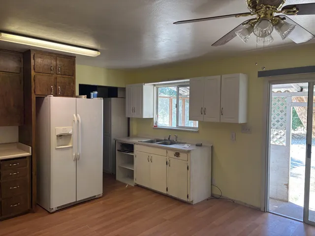 a kitchen with a refrigerator a sink and dishwasher with wooden floor