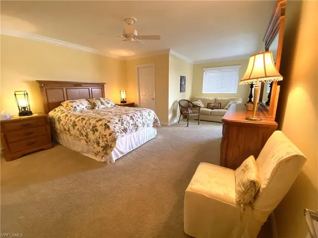 a spacious bedroom with a bed a couch and dresser in it