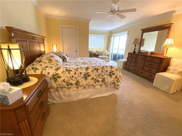 a spacious bedroom with a bed and dresser with mirror