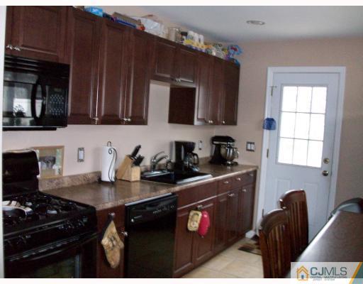 33 West Knollwood Road Edison, NJ 08817 - Photo 3 of 9 a kitchen with a sink a stove and cabinets