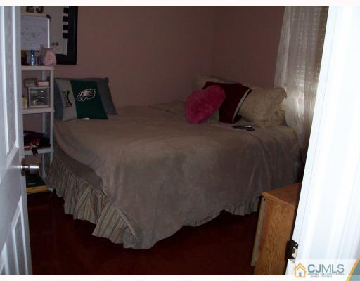 33 West Knollwood Road Edison, NJ 08817 - Photo 6 of 9 a bed sitting in a bedroom next to a window