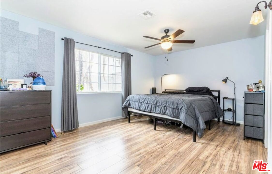 13447 Filmore Street Pacoima, CA 91331 - Photo 6 of 12 a bedroom with a bed and wooden floor