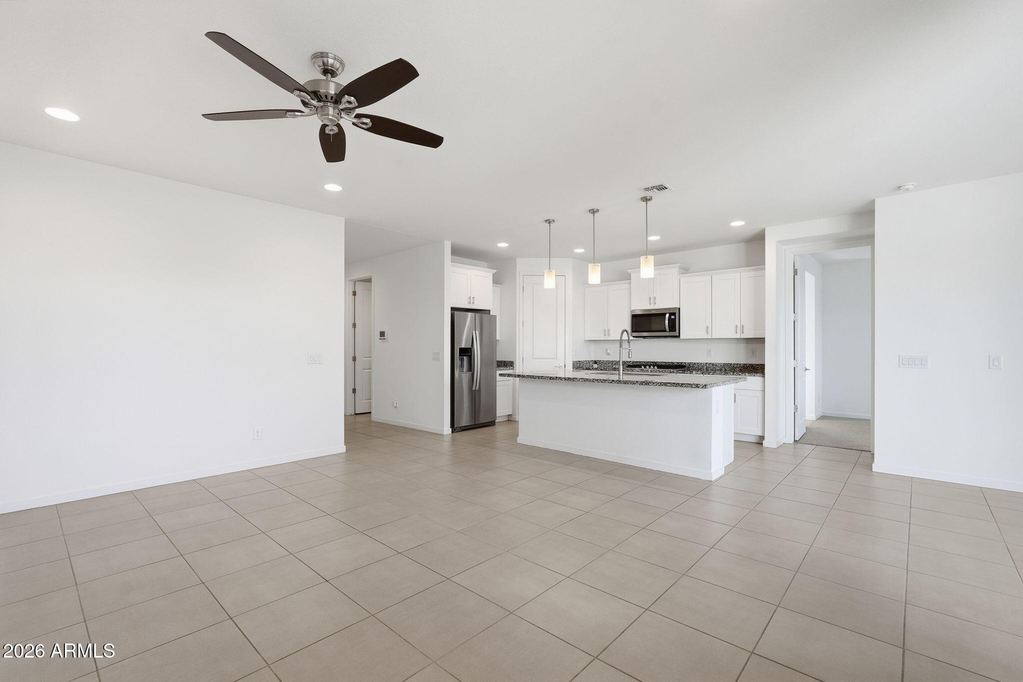 5621 West Notch Hill Road Laveen, AZ 85339 - Photo 5 of 49 a large kitchen with kitchen island a stove a refrigerator a sink dishwasher with a stove and white cabinets