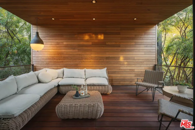 a view of a patio with couches chairs and wooden floor