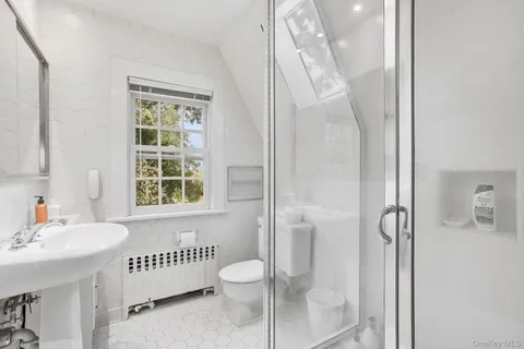 a bedroom with a bed a chair and next to a window