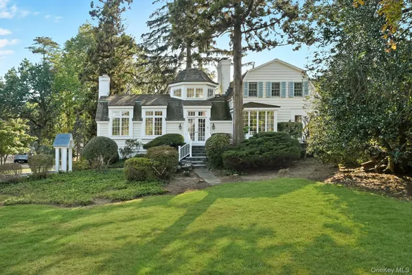 a front view of a house with a yard and trees
