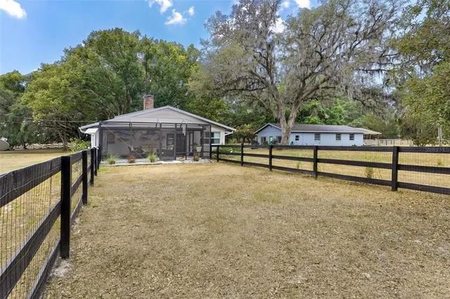 a kitchen with stainless steel appliances a dining table chairs stove refrigerator and cabinets