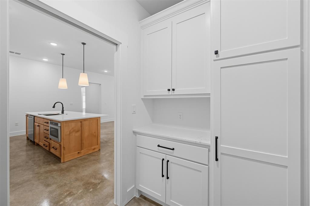 102 Cardinal Wds Granbury, TX 76049 - Photo 11 of 36 Bar area with white cabinets, finished concrete floors, hanging light fixtures, recessed lighting, and stainless steel appliances