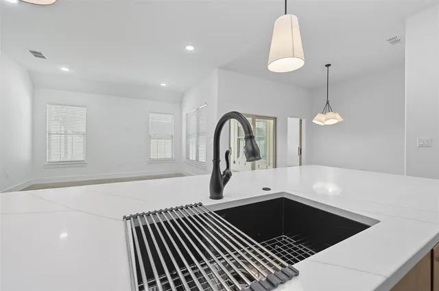 a view of a kitchen with kitchen island a sink stainless steel appliances and cabinets