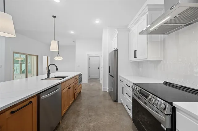 a view of a kitchen with a sink and dishwasher with wooden floor