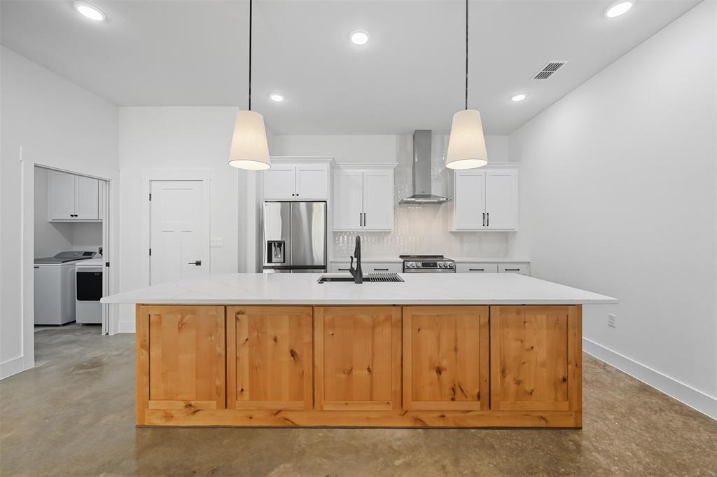102 Cardinal Wds Granbury, TX 76049 - Photo 5 of 36 Kitchen featuring concrete flooring, white cabinetry, stainless steel appliances, decorative backsplash, and an island with sink