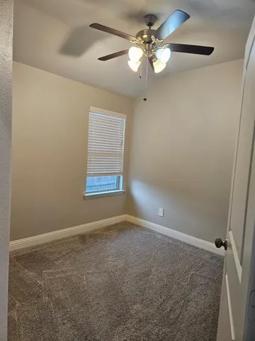 en empty room with windows and fan