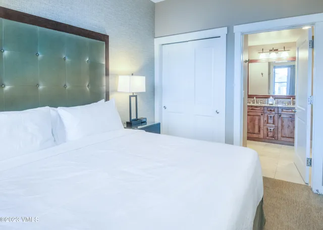 a bedroom with a large bed and a chandelier