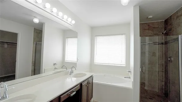 an empty room with wooden floor chandelier fan and windows