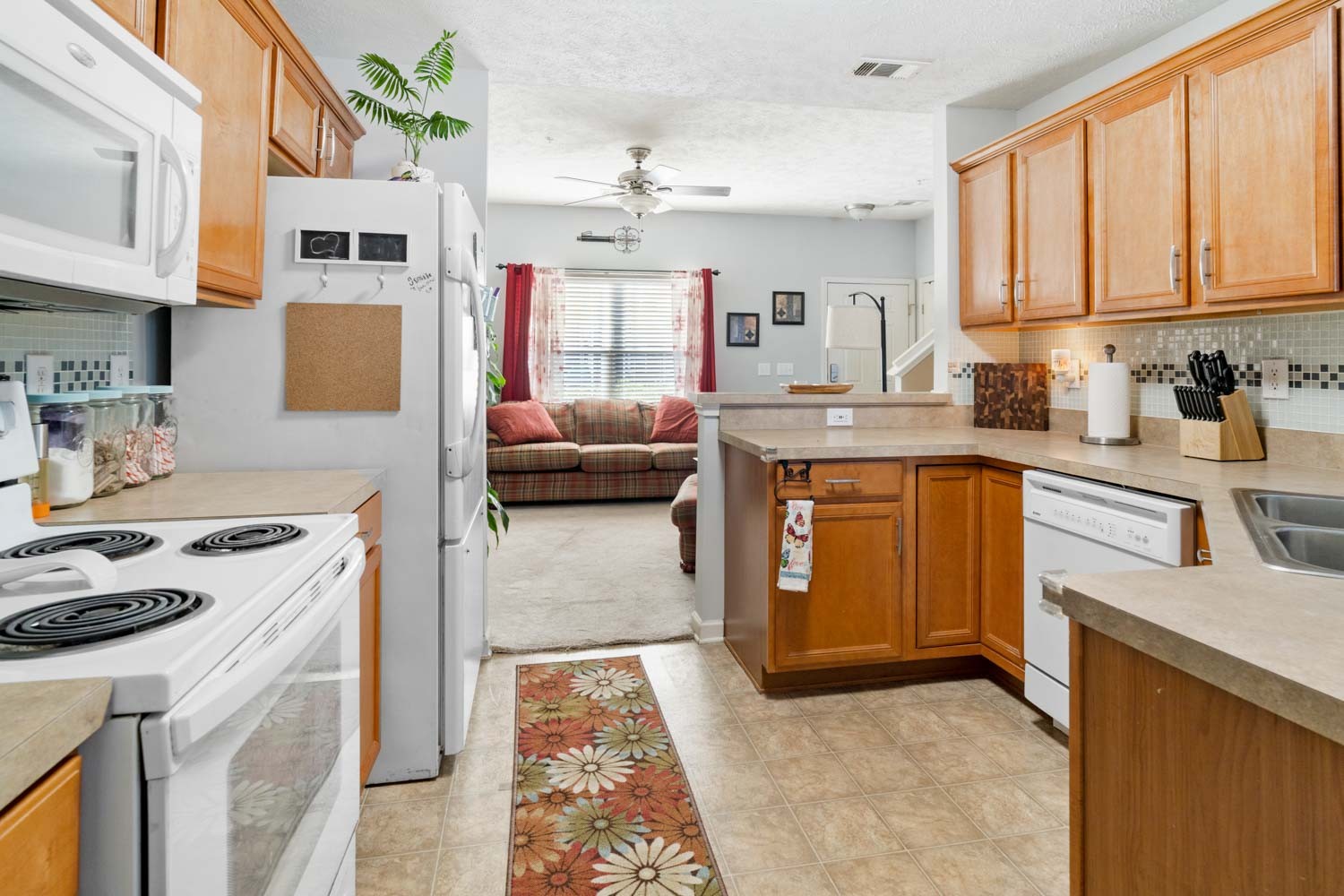 2018 Arum Court Spring Hill, TN 37174 - Photo 9 of 38 a kitchen with stainless steel appliances granite countertop a stove a sink dishwasher and a refrigerator with wooden cabinets
