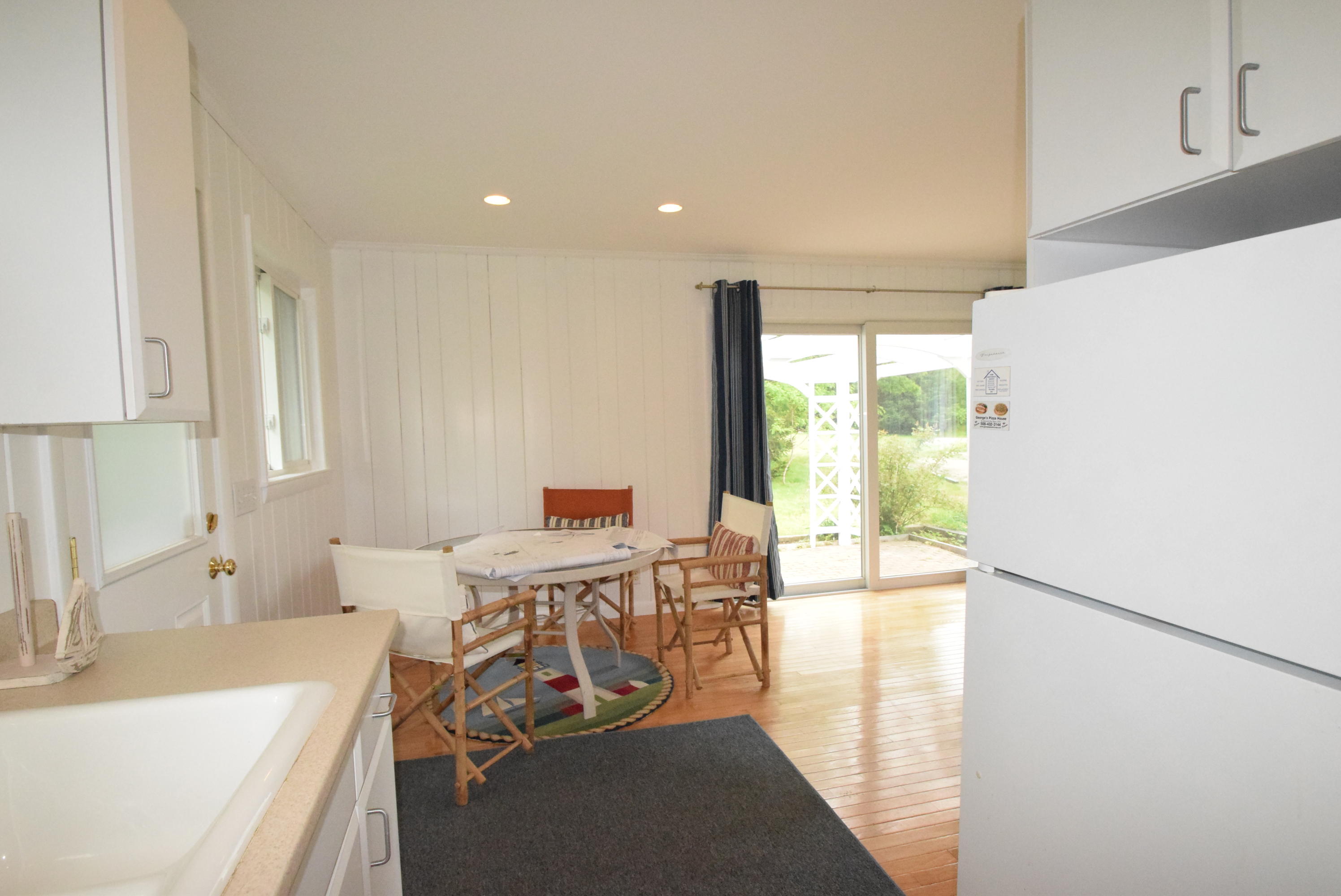 164 Breakwater Road Brewster, MA 02631 - Photo 48 of 57 a view of a kitchen with a dining table chairs and a kitchen