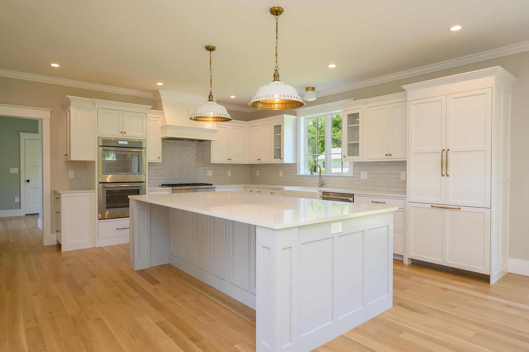 164 Breakwater Road Brewster, MA 02631 - Photo 7 of 57 a kitchen with kitchen island a sink a stove a refrigerator and white cabinets with wooden floor