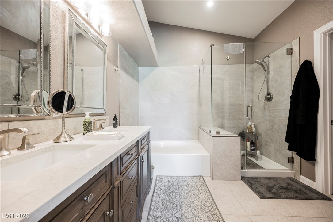 7625 Rolling View Drive, Unit 202 Las Vegas, NV 89149 - Photo 18 of 28 Full bathroom with a garden tub, double vanity, a shower stall, and light tile patterned floors