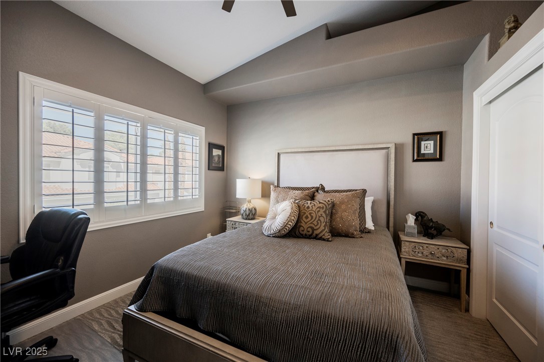 7625 Rolling View Drive, Unit 202 Las Vegas, NV 89149 - Photo 20 of 28 Bedroom with vaulted ceiling, a ceiling fan, a desk, and dark colored carpet