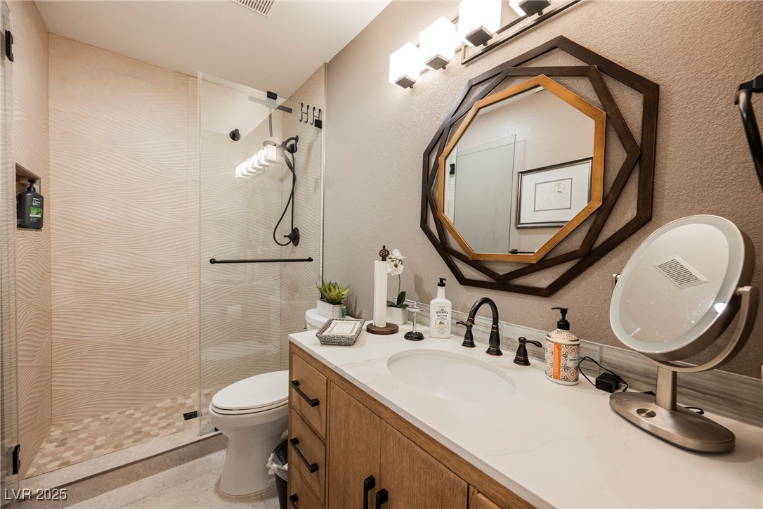 7625 Rolling View Drive, Unit 202 Las Vegas, NV 89149 - Photo 24 of 28 Bathroom with a stall shower, vanity, and a textured wall