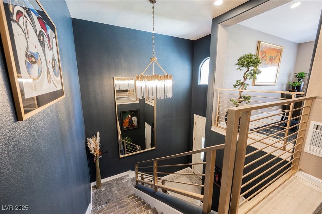 7625 Rolling View Drive, Unit 202 Las Vegas, NV 89149 - Photo 4 of 28 Stairs featuring a chandelier and a textured wall