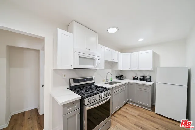 a kitchen with white cabinets and white appliances