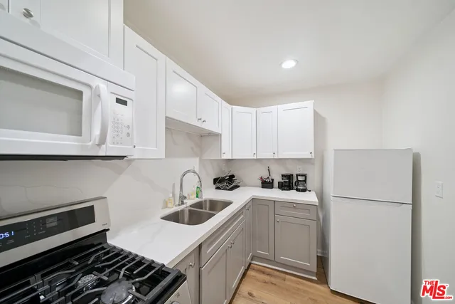 a kitchen with sink a refrigerator and cabinets