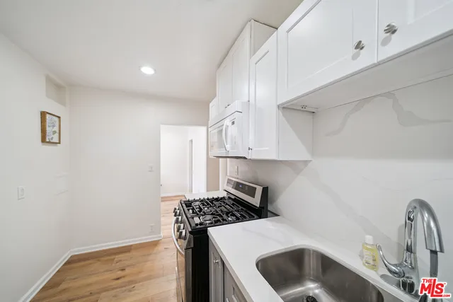 a kitchen with a sink stove and cabinets